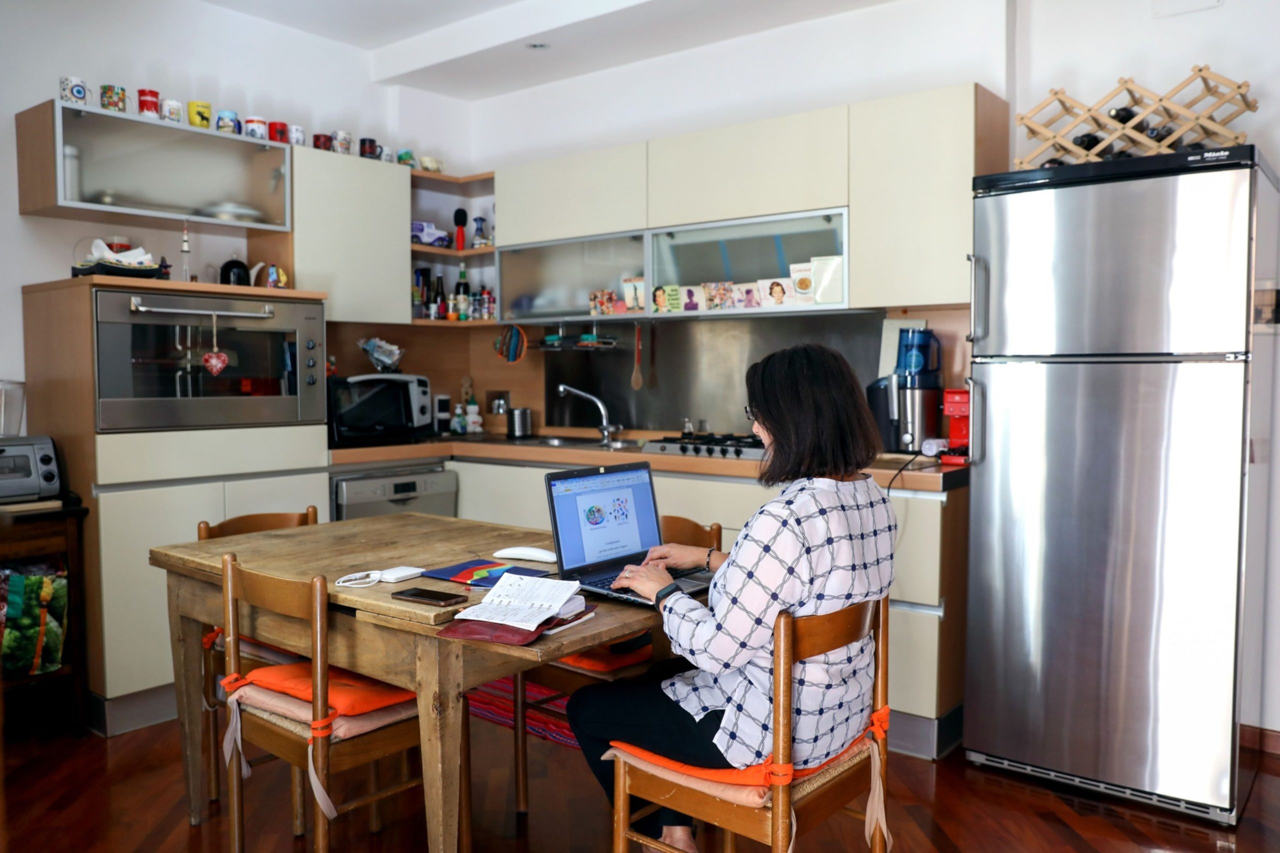 A worker uses a laptop computer whilst working from home at a table in her kitchen in Rome, Italy, on Oct. 8, 2020